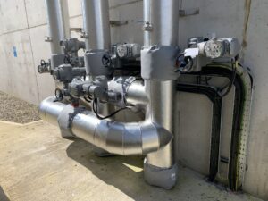 Pipework insulated with fiberglass rockwool sections and clad with aluminium in a waste water treatment facility in Donegal