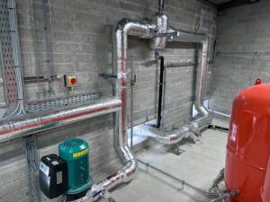 Industrial pipework with circulation pump and dirt separator insulated with foiled fiberglass