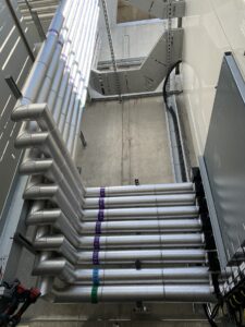 Insulated external pipework beside an industrial building